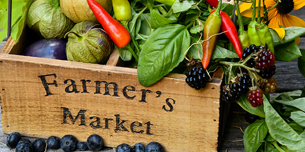 Wooden Farmer's Market crate filled with fresh basil, chili peppers, tomatillos and blackberries