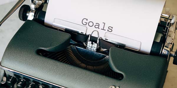 typewriter with paper that says goals