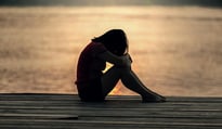 woman hiding face on dock