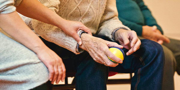 womens hand with comforting grasp on an elderly hand