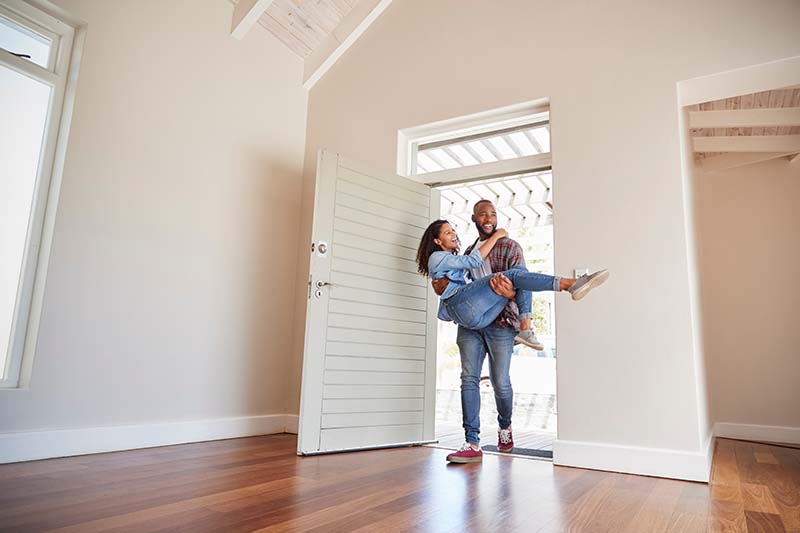 Newlywed couple walking into their new home