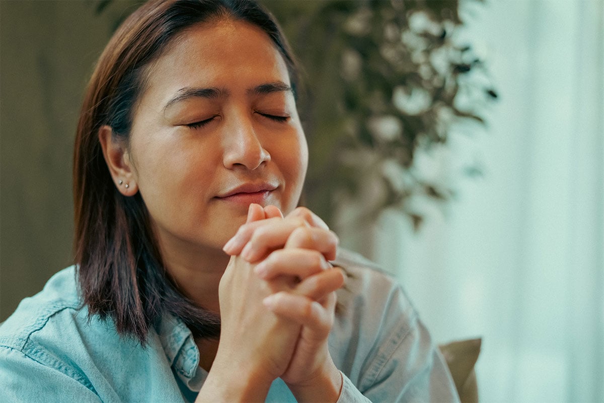 Person with praying hands waiting on answered prayer