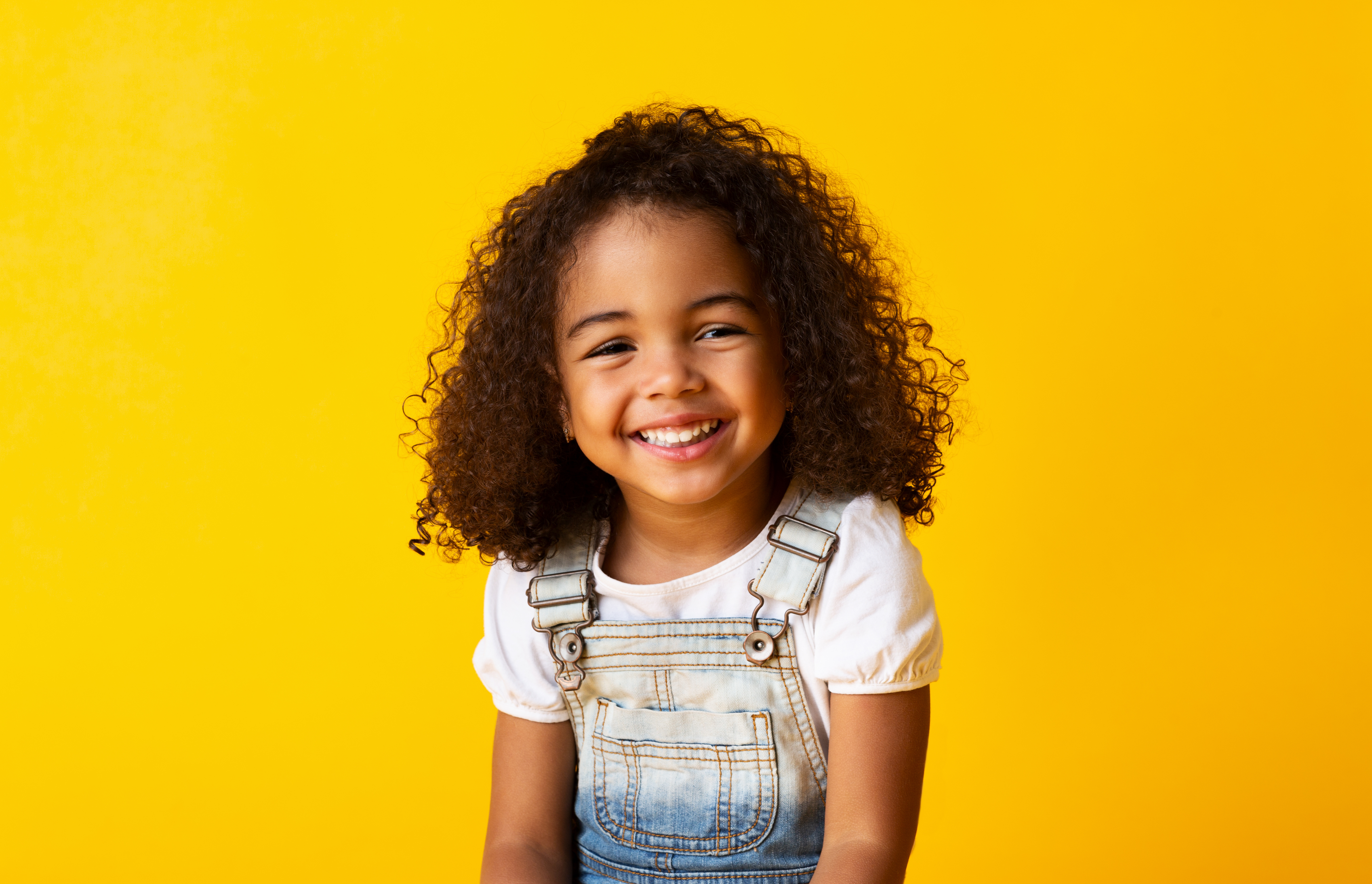 A young girl smiling for a picture. 