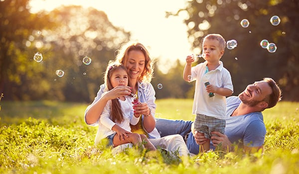 Family playing outside with bubbles.