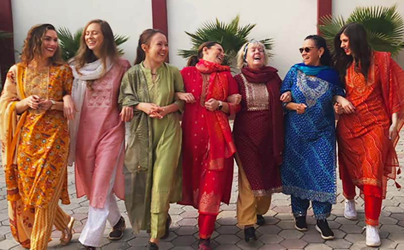 women locking arms walking in South Asia