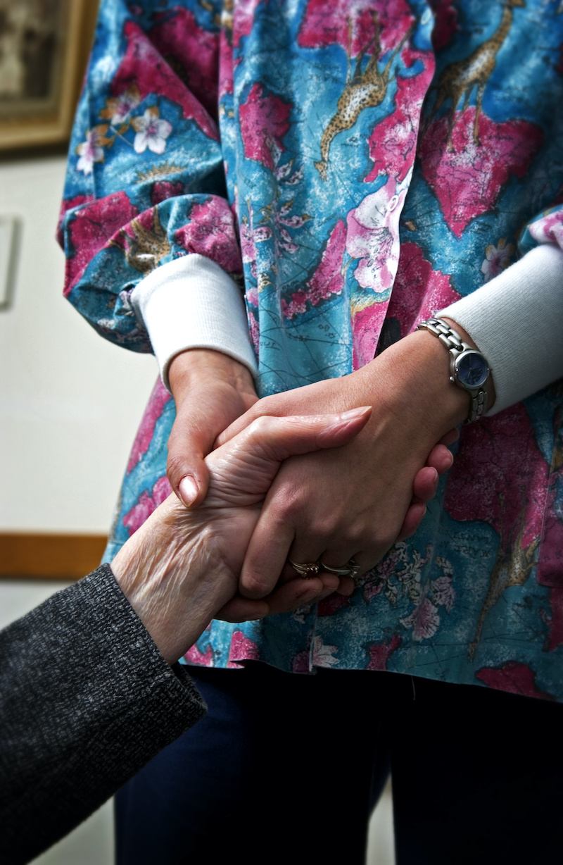 Nurse holding patient hand