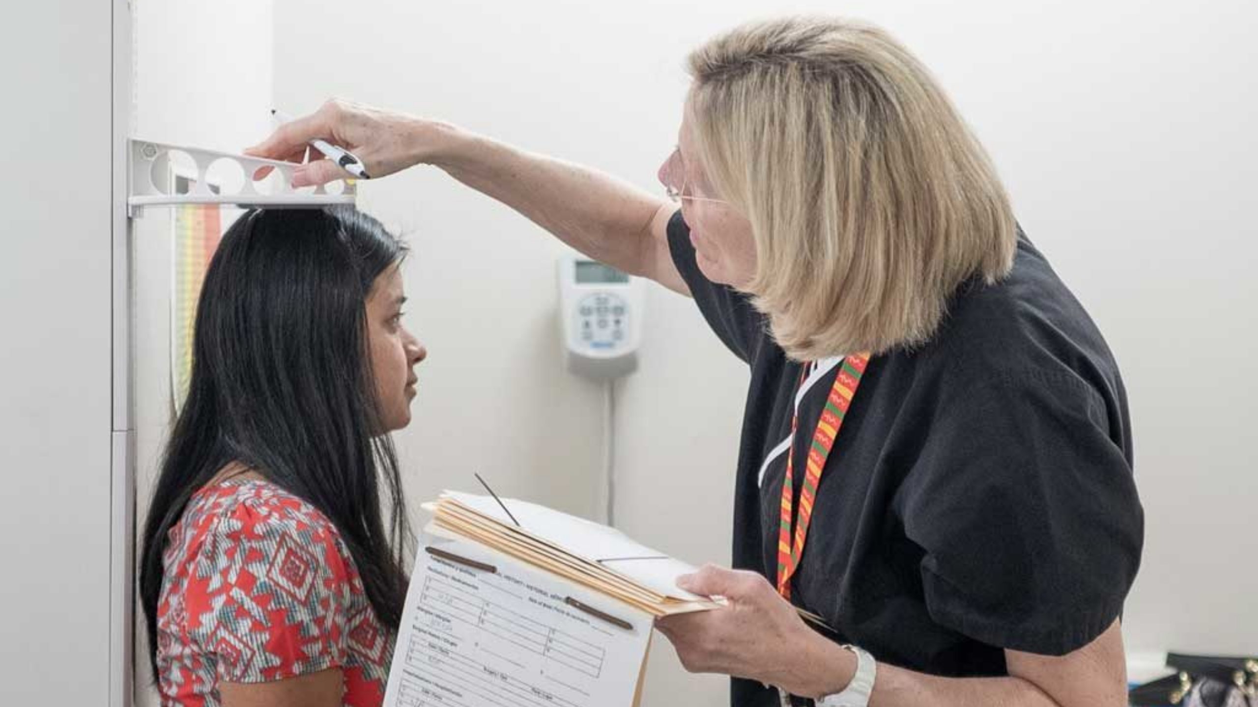A woman getting her height measured at a doctor's office