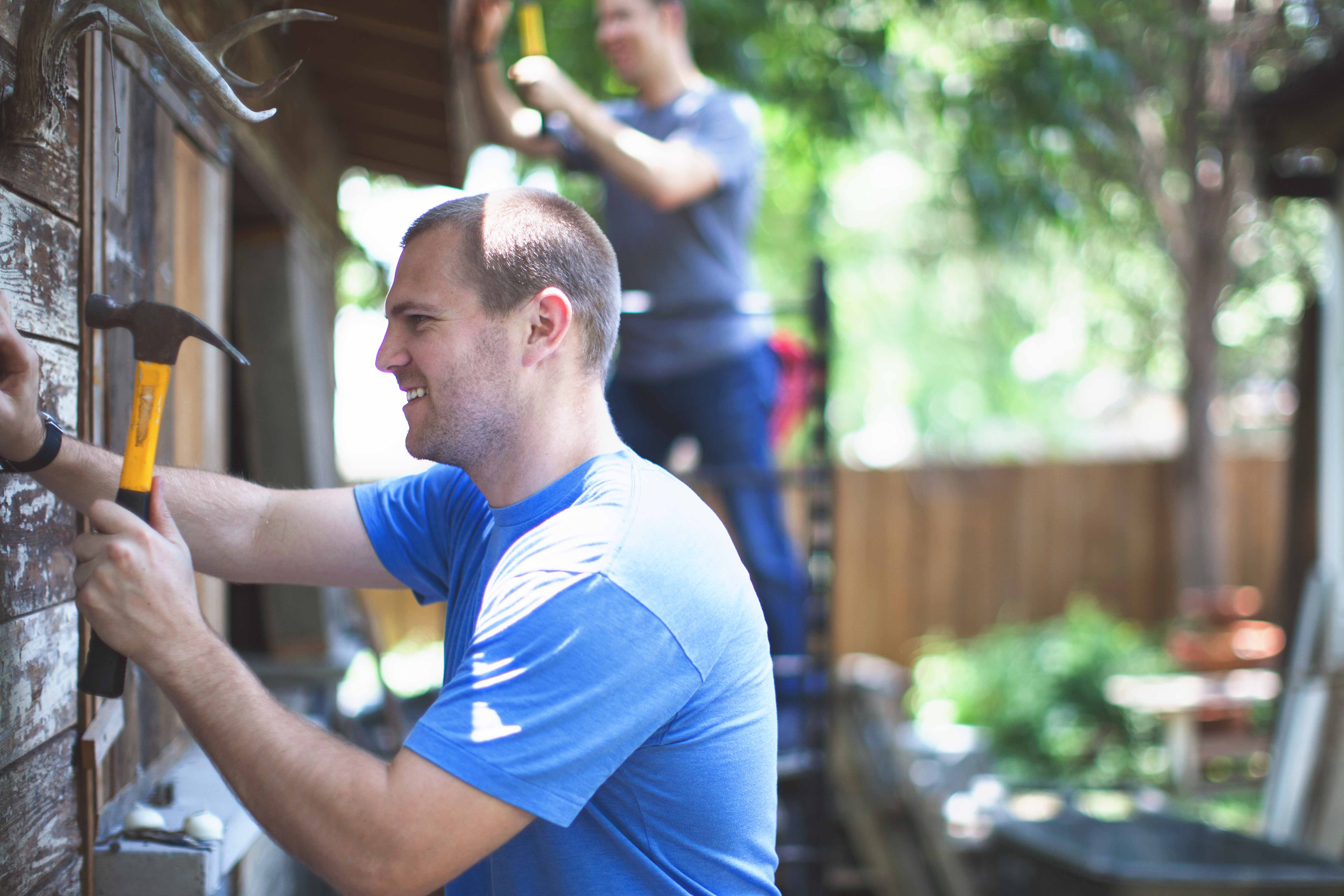 Two men volunteering outside of a home