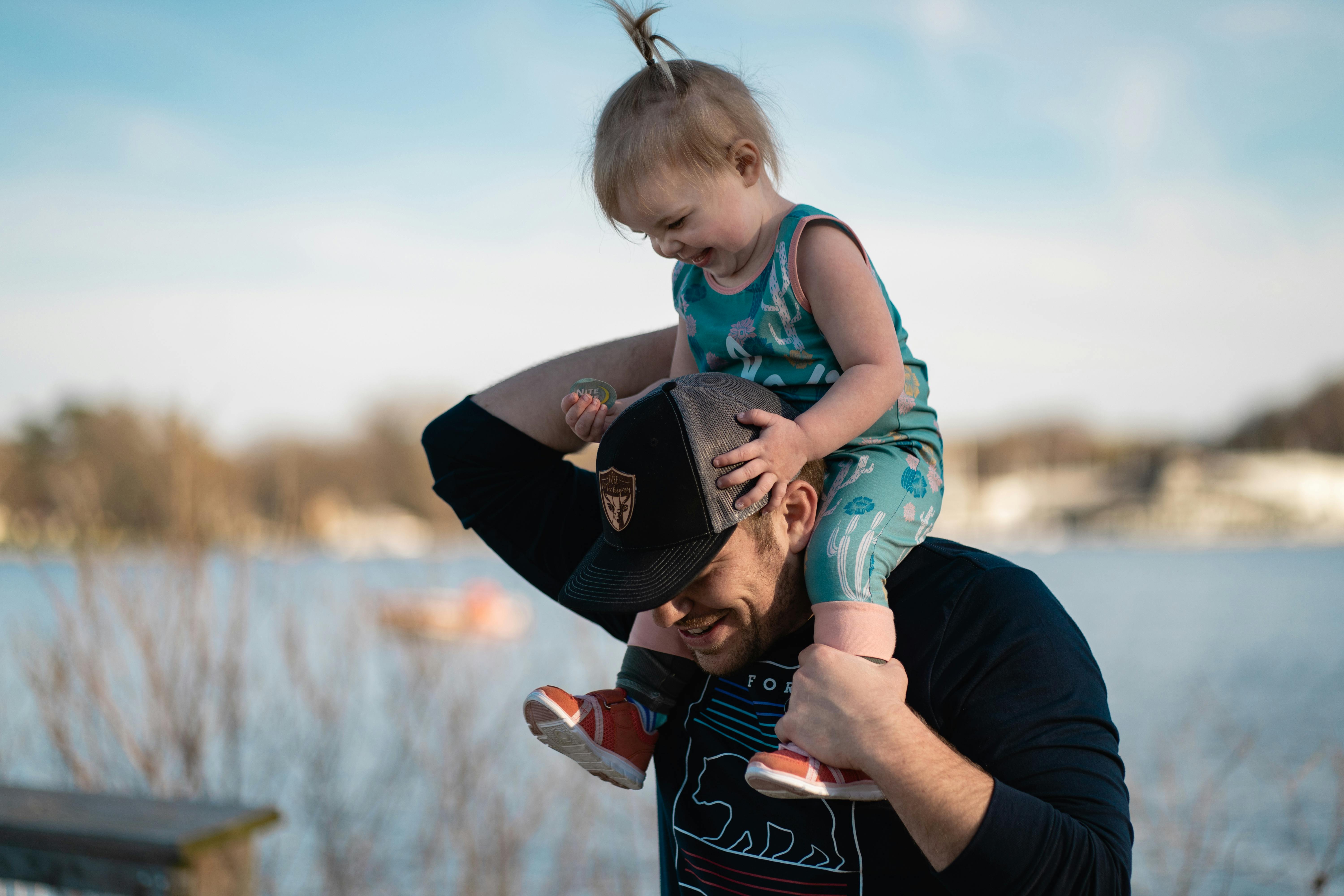 Dad carrying daughter on his shoulders